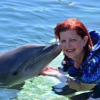 Judy Rohlin swimming beside a friendly dolphin