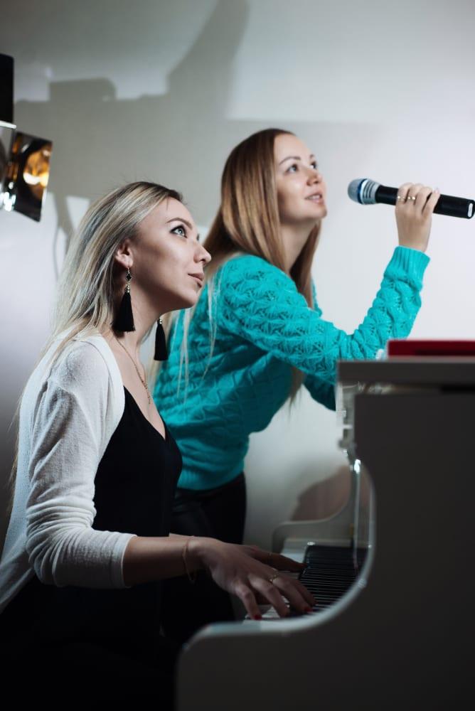 A pianist accompanying a singer who is holding a microphone, following her in real time