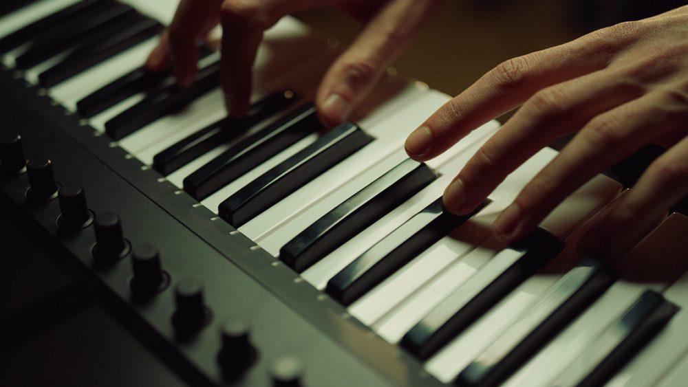 Close-up of hands playing on piano keys