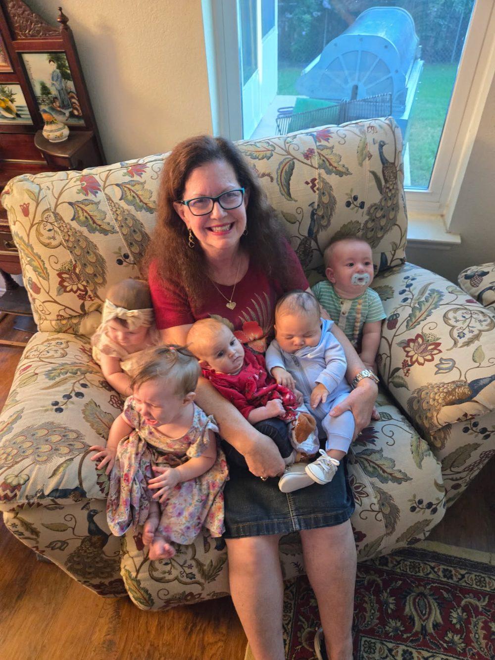 Judy Rohlin, a grandmother many times over, holding five of her grandchildren