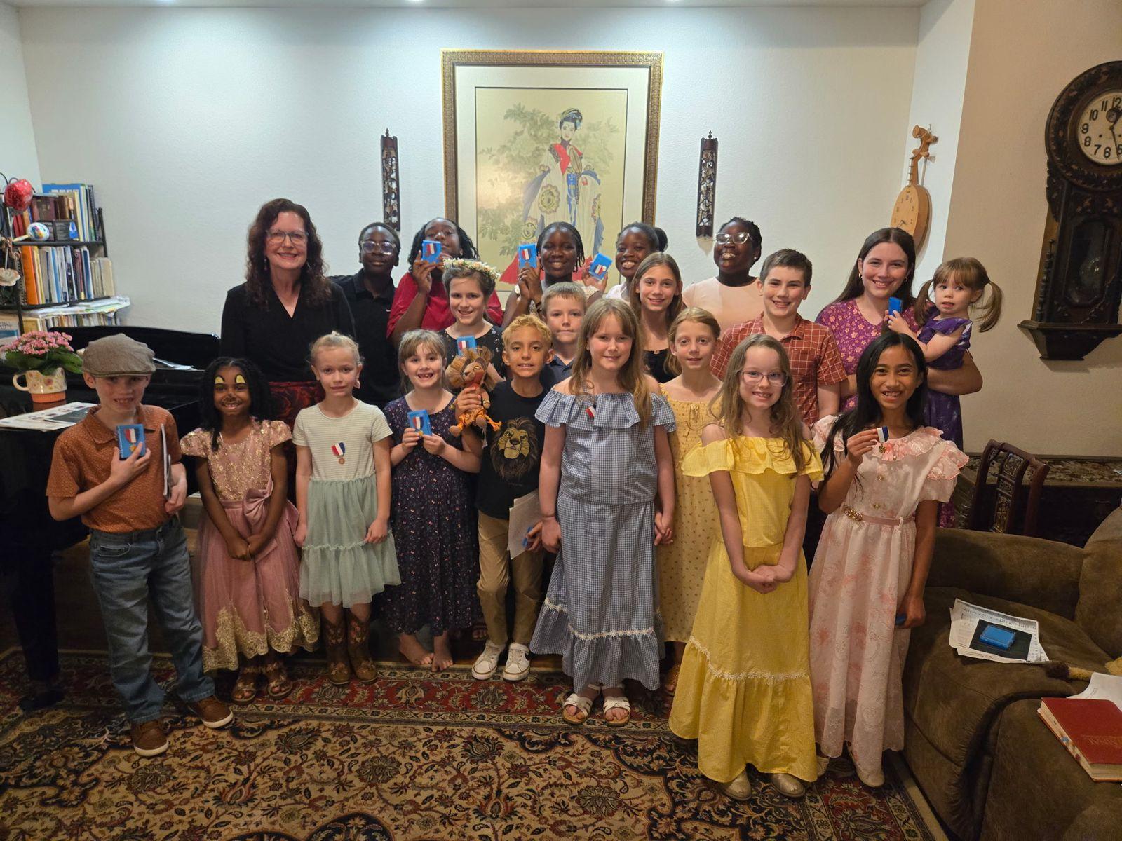 Judy Rohlin with her piano students at a studio recital, the students holding their achievement medals