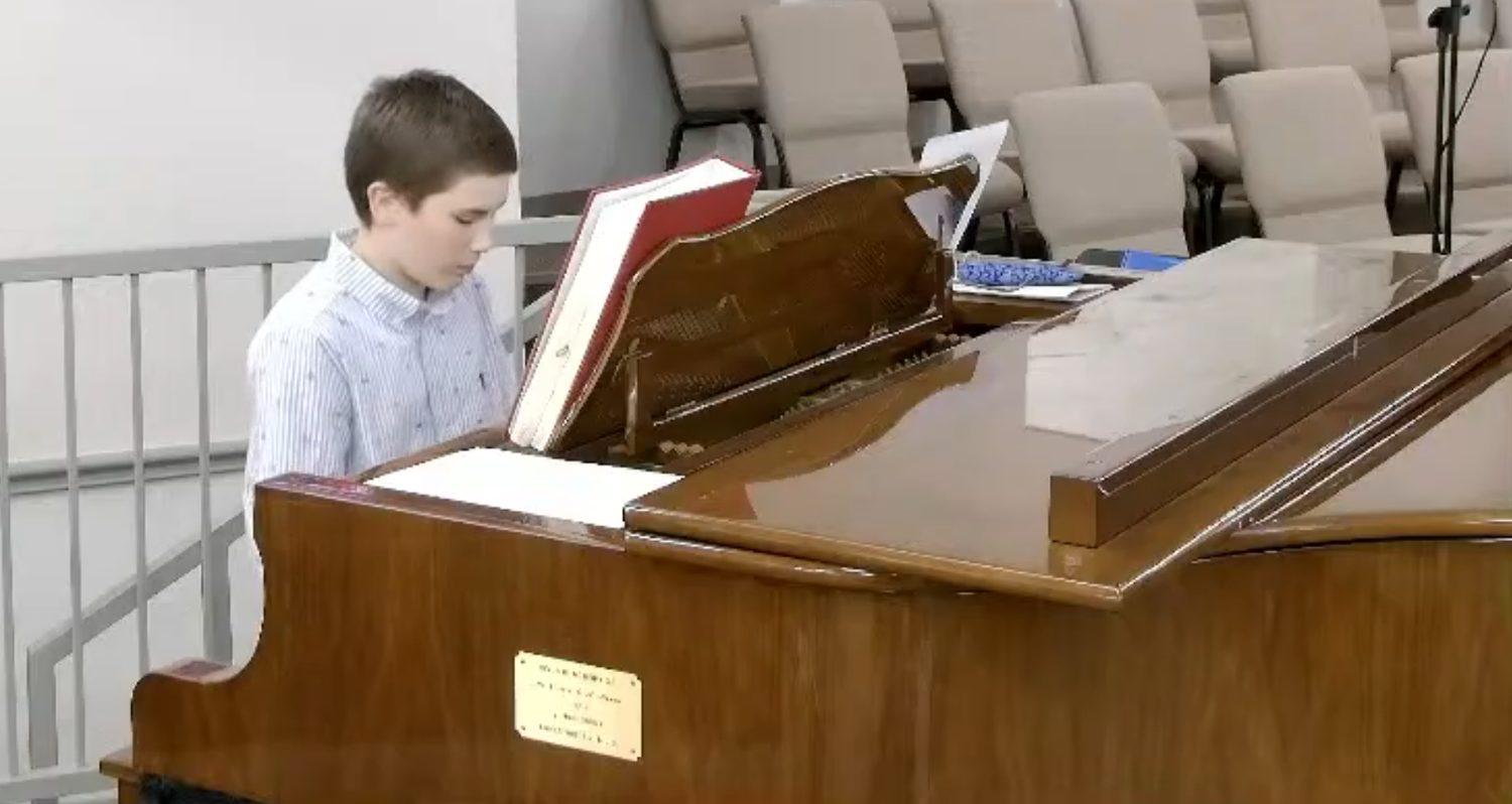 Judy's 14-year-old student and grandson playing piano during a church service in Cleburne, Texas